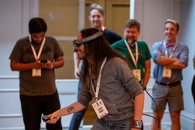 CommCon attendees watch and smile as Lorenzo plays with a Magic Leap AR headset and controller